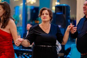 Party guests dancing in coordinated movements at an indoor celebration.