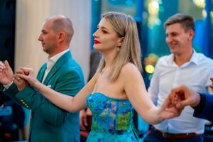 Guests dancing together at an elegant indoor venue with atmospheric blue lighting.