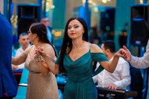 Dancers in formal attire moving gracefully at an indoor social event.