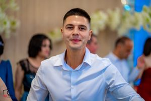 Smartly dressed guest at a formal event wearing a light blue dress shirt.
