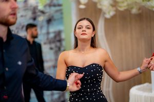 Dancer in a strapless black sequined dress performing at an elegant event.