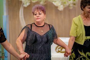 Guest in a black mesh formal dress dancing at an elegant celebration.