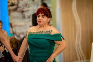 Guest in an emerald green off-shoulder dress at a formal celebration.
