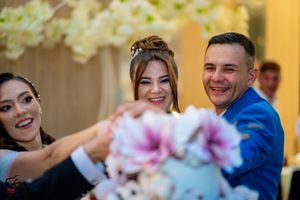 Wedding celebration with guests admiring decorated cake at elegant reception venue.