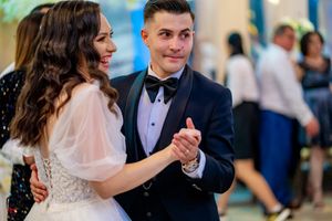 Wedding guests dancing together in formal wear during evening reception celebration.
