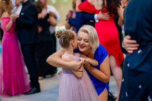 Festive wedding reception dance floor filled with couples in vibrant dresses and suits.