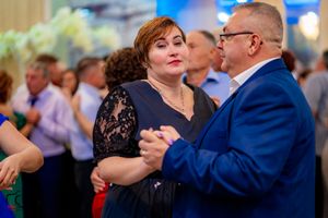 Couples dancing together during a wedding celebration with blue lighting and decorative elements.