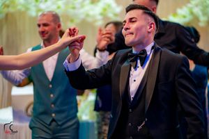 Formal event attendees dance and celebrate in a festively decorated venue.