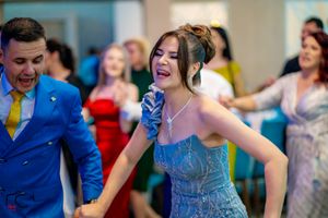 Joyful celebration with guests dancing and laughing at an indoor reception.