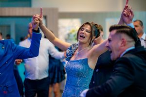 Energetic dance party with guests celebrating at an indoor wedding reception.
