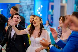 Party guests laugh and dance together during a festive celebration.