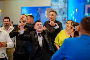 Enthusiastic guests celebrate and sing at a formal event with ambient lighting.