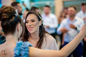 Formal celebration with guests in elegant attire enjoying a dance party moment.