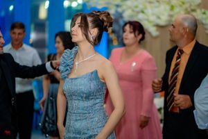 Wedding guests dancing and celebrating at reception with blue ambient lighting.