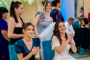 Guests perform synchronized dance moves at an indoor wedding celebration.