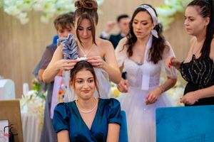 Wedding party members dance in formation during indoor reception celebration.