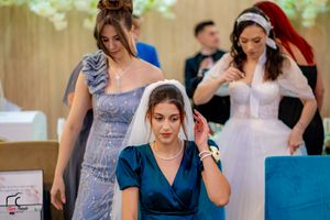 Wedding guests perform coordinated dance moves at indoor reception venue.