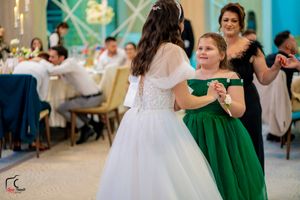 Couples dancing together at a wedding reception with decorative lighting and warm ambiance.