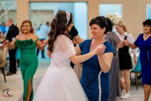 Wedding reception dance floor filled with guests in formal attire enjoying the celebration.
