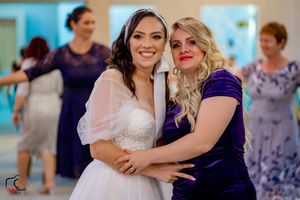 Joyful wedding guests dance in pairs during reception with elegant lighting and decor.