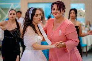 Reception guests share dance floor moments in formal wear at wedding celebration.