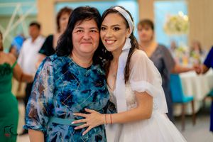 Wedding celebration with guests dancing and embracing at a lively reception party.