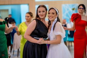 Wedding party guests dancing and hugging during a festive indoor celebration.