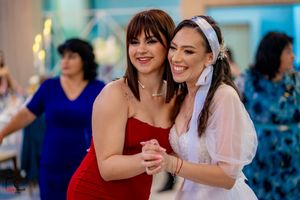 Joyful celebration with guests in colorful dresses dancing at a wedding reception.