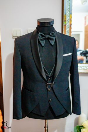 Collection of elegant black formal suit jackets displayed on hangers.