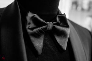 Close-up detail of a black bow tie against formal attire.