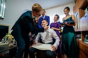 A bright indoor scene showing people gathered during formal preparations with natural lighting.
