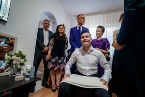 A casual moment captured in a living room with formal attire and home decor visible.