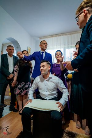 A lively indoor gathering shows people in formal wear interacting in a bright room setting.