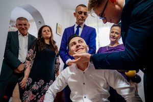 Wedding guests gather around for a lively party game during a reception celebration.