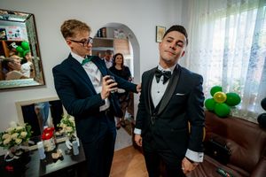 Formal event preparation with suits and festive decorations in living room.