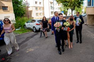 Wedding party members walking together on a residential street.
