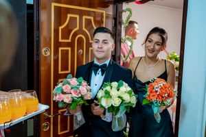 Wedding party members holding decorative props during indoor celebrations.