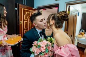 A tender exchange between a couple with a bouquet of pink roses.