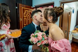 A romantic moment shared between a couple with pink roses during a wedding celebration.