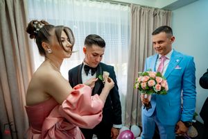 A joyful moment during wedding preparations with pink roses and formal attire.