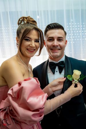 Close-up shot of wedding party members helping with boutonniere pinning ceremony.