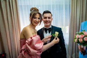 Formal group gathered for boutonniere pinning during wedding preparations.