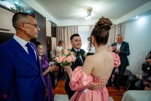 Wedding preparation candid moments captured in indoor venue setting.