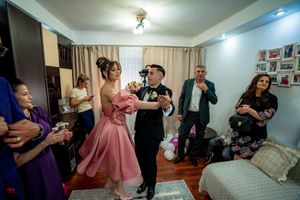 People dancing and celebrating at an indoor party with pink decor and balloons.