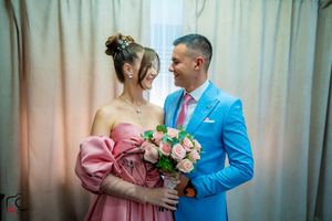 A romantic moment captured between a couple in pink and blue formal attire.