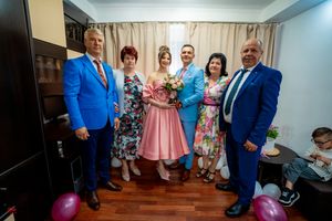 Extended family gathering in formal attire with pink and blue color scheme.