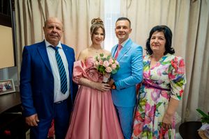 Celebration group photo showing attendees in coordinated pink, blue and floral formal wear.