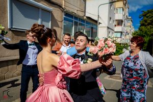 Wedding celebration with dancers in pink and blue outfits moving dynamically on a street.