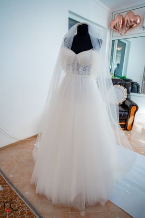 White tulle wedding dress with sweetheart neckline displayed on a mannequin in a bridal boutique.