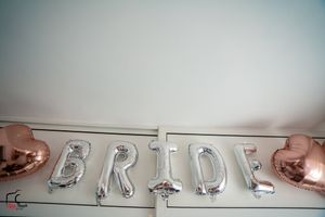 Silver foil letter balloons spelling out 'BRIDE' with rose gold accents against a light background.